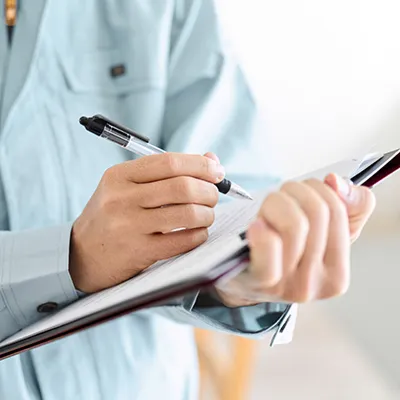 Hands holding and writing on a clip board